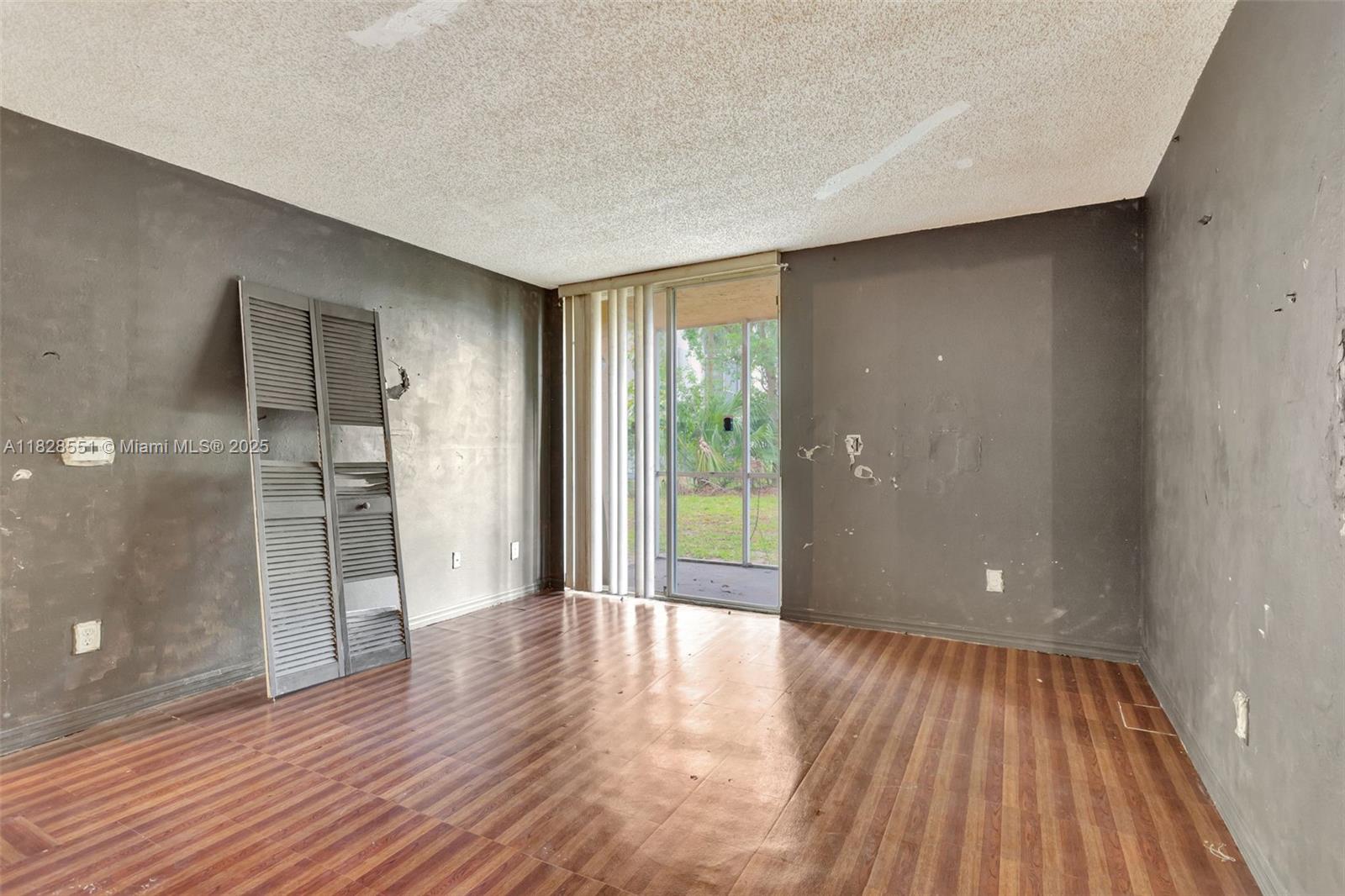 4055 West McNab Road, Unit H103 Pompano Beach, FL 33069 - Photo 2 of 21 a view of an empty room with wooden floor and a window