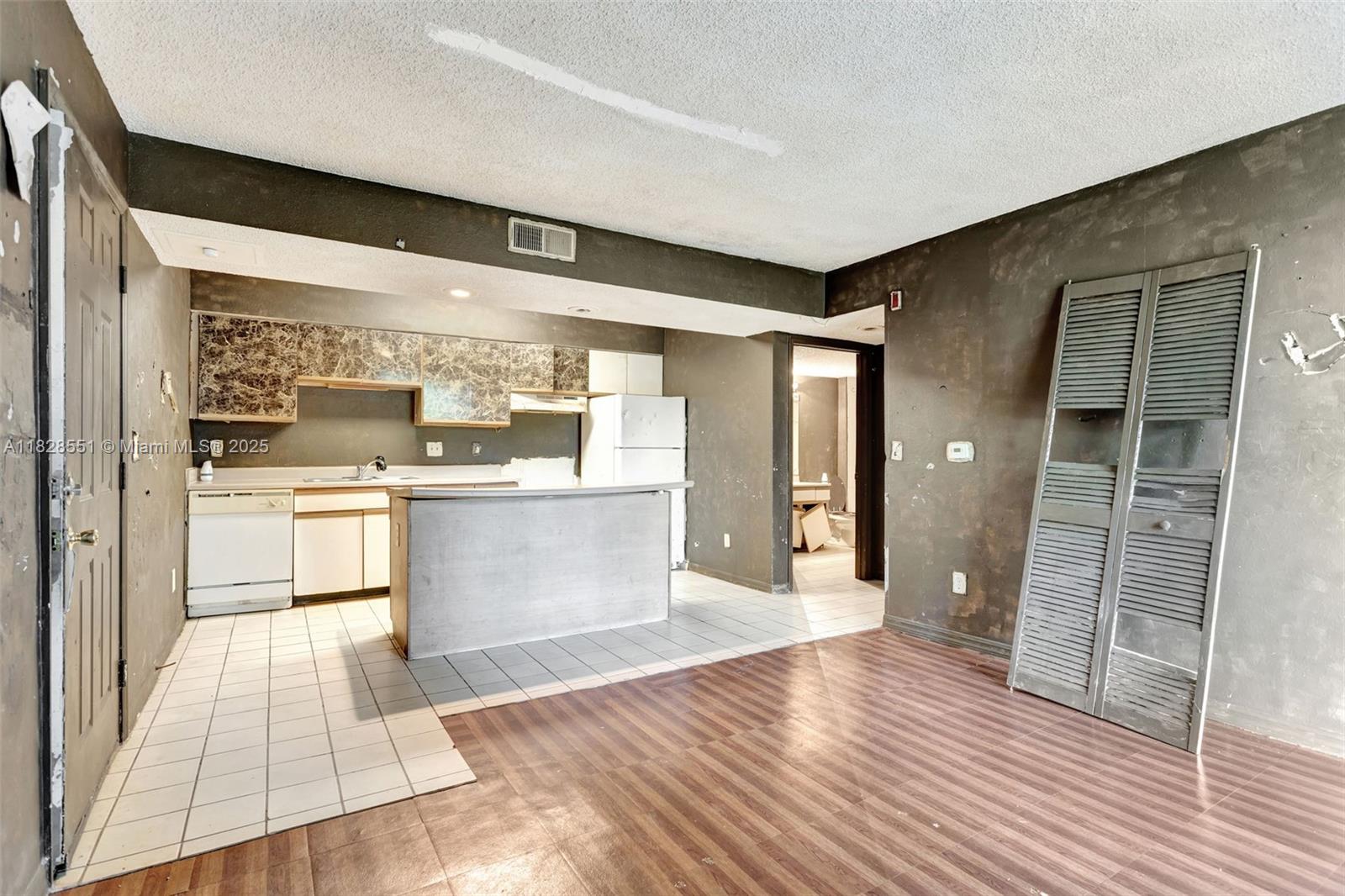 4055 West McNab Road, Unit H103 Pompano Beach, FL 33069 - Photo 3 of 21 a large white kitchen with wooden floor