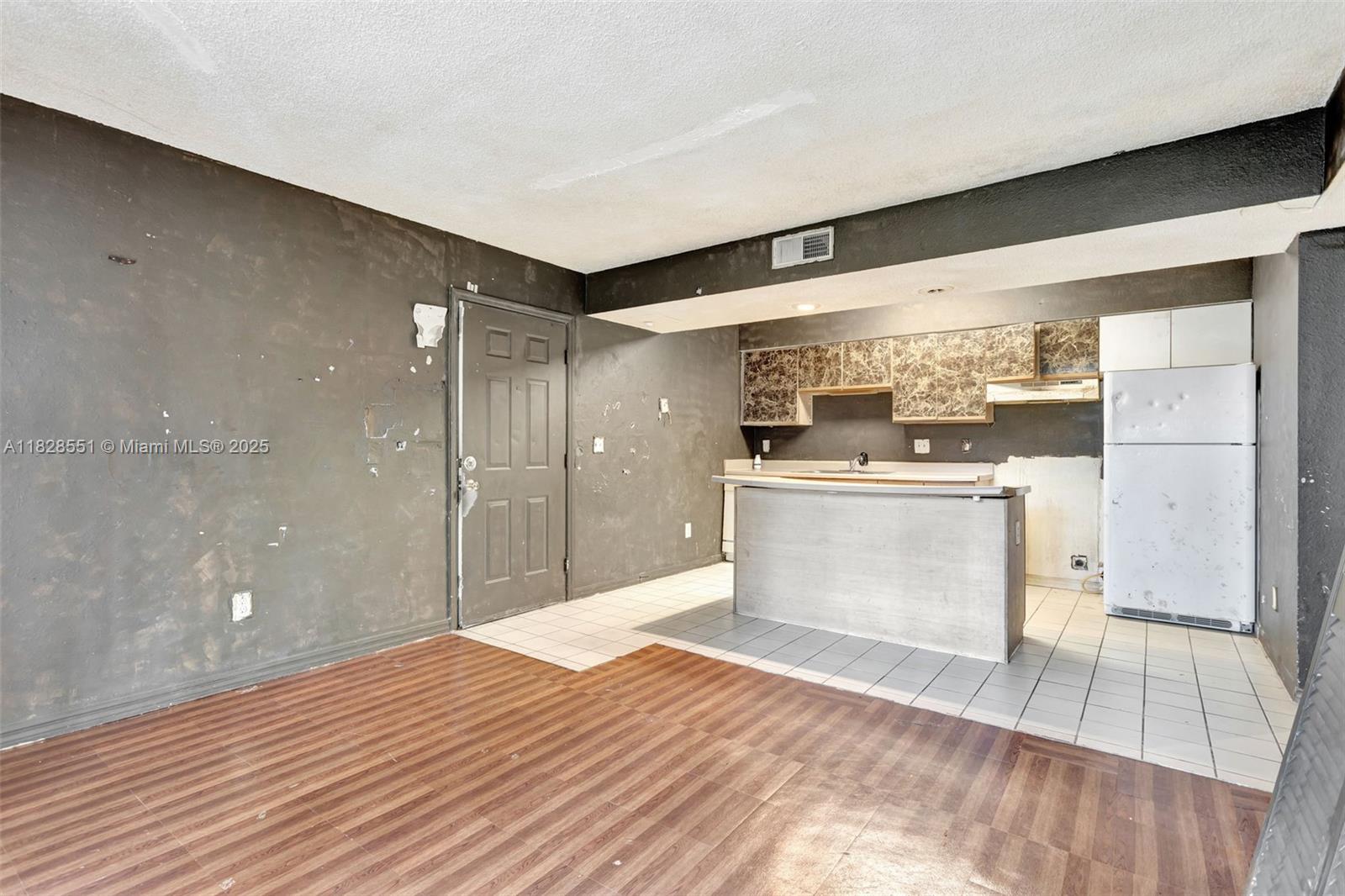 4055 West McNab Road, Unit H103 Pompano Beach, FL 33069 - Photo 4 of 21 a kitchen with stainless steel appliances wooden floor sink and wooden cabinets