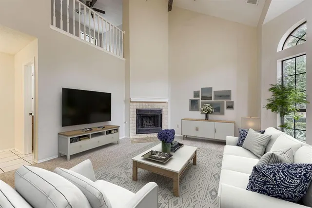 a living room with furniture a flat screen tv and a fireplace