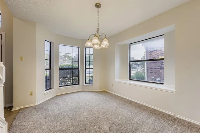 an empty room with windows and chandelier
