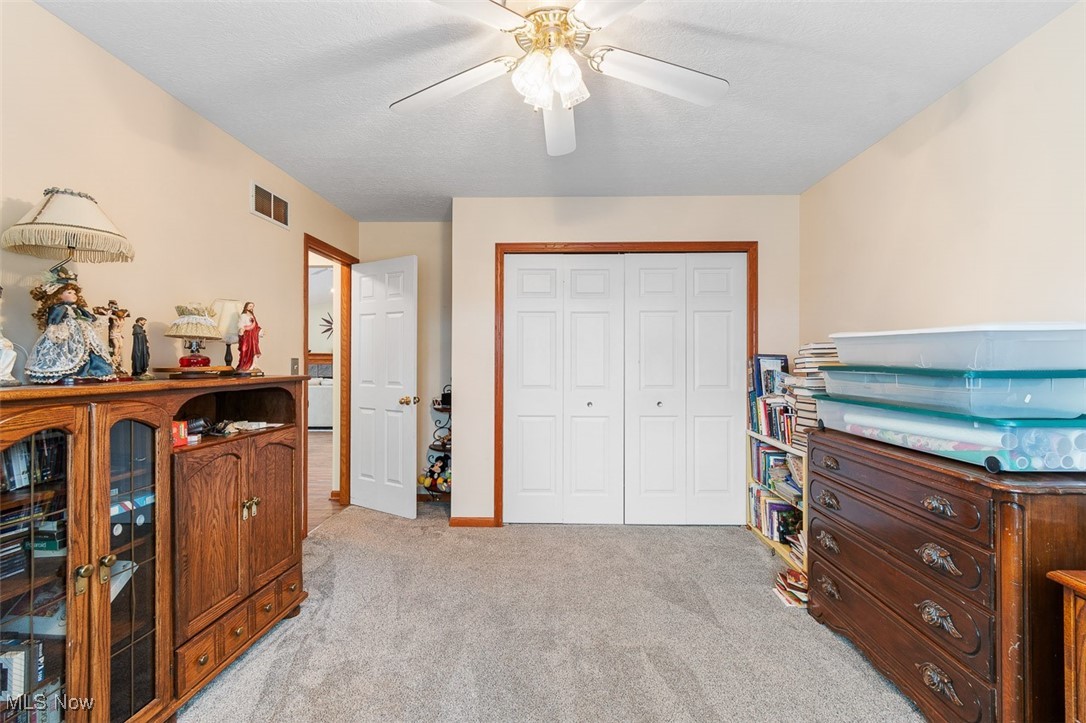 2271 Graybill Road Uniontown, OH 44685 - Photo 25 of 44 Bedroom with a closet, visible vents, light colored carpet, and a ceiling fan