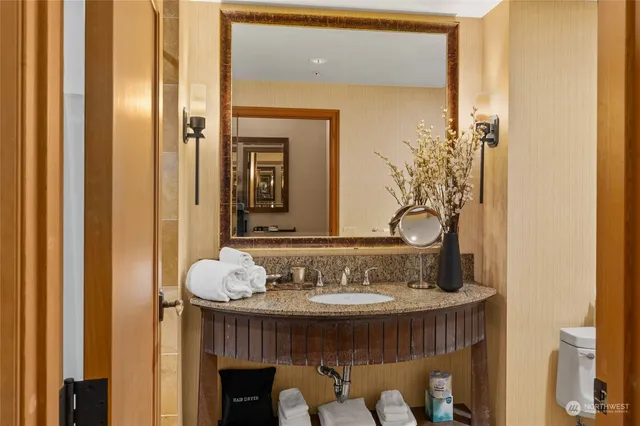 a bathroom with a granite countertop sink and a mirror