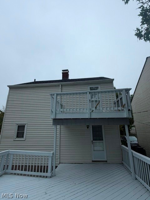 1388 Cranover Road Lyndhurst, OH 44124 - Photo 6 of 35 Two-story deck system with a lower-level deck and an upper-level balcony, white siding, and a visible chimney
