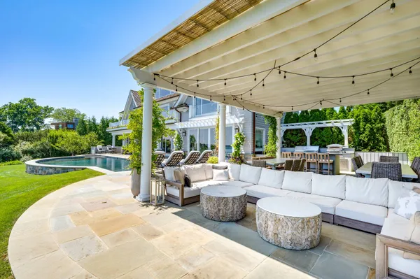 a view of a patio with couches chairs and floor to ceiling window
