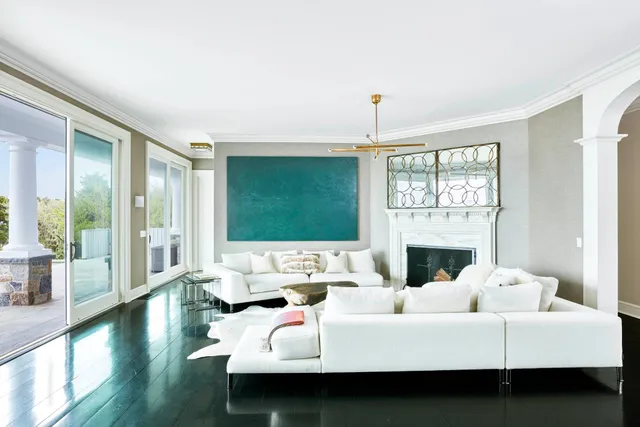 a living room with furniture fireplace and a large window