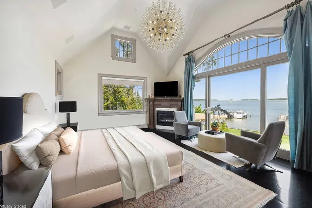 a bedroom with a bed a large window and a flat tv screen