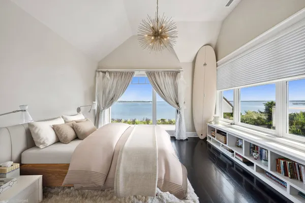 a bedroom with furniture and a large window