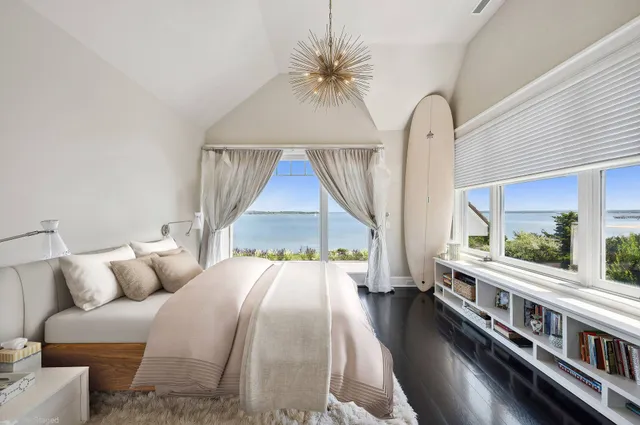 a bedroom with furniture and a large window