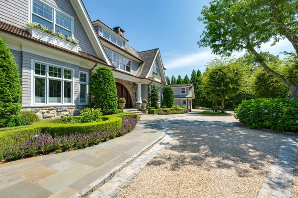 a front view of a house with a yard and potted plants
