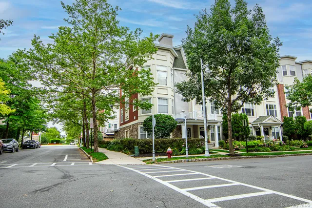a kitchen with a sink a stove a refrigerator cabinets and a dining table with wooden floor