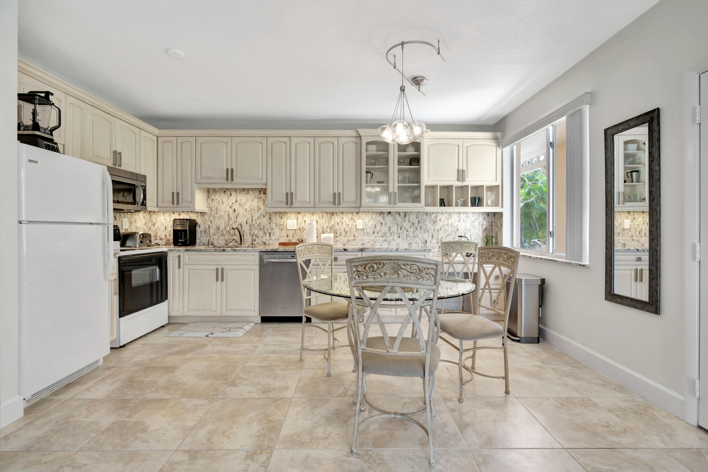 353 Highway 1, Unit A4 Jupiter, FL 33477 - Photo 12 of 51 a kitchen with stainless steel appliances kitchen island granite countertop a refrigerator and a stove top oven