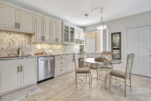 a kitchen with cabinets chairs and white appliances