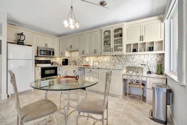 a kitchen with kitchen island a stove a table and chairs