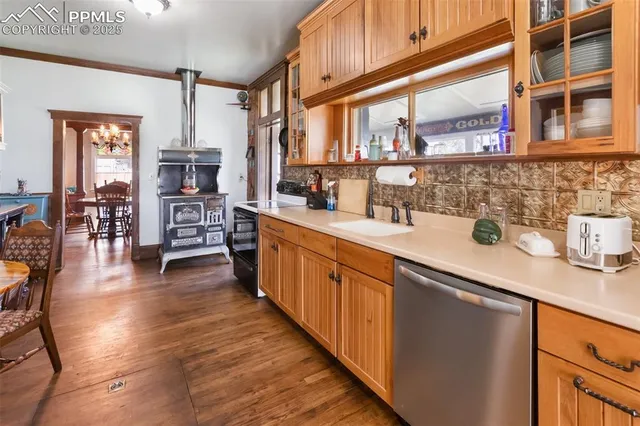 a kitchen with stainless steel appliances granite countertop a stove and a wooden floors