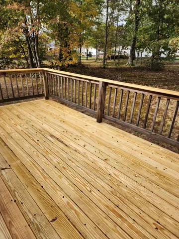 a view of balcony with wooden floor and fence