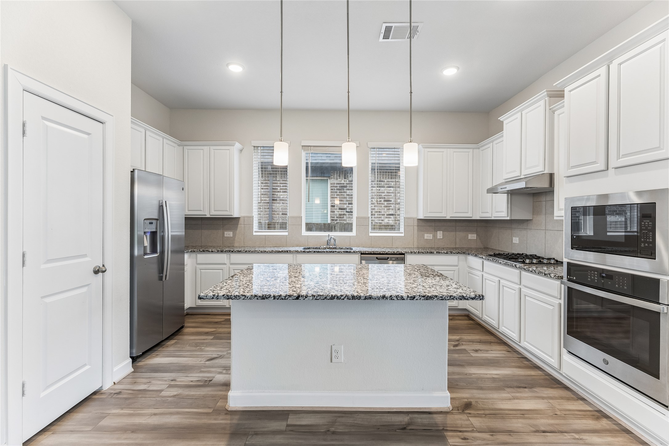 298 Wild Pecan Loop Buda, TX 78610 - Photo 9 of 40 a kitchen with stainless steel appliances granite countertop a stove a sink and a refrigerator