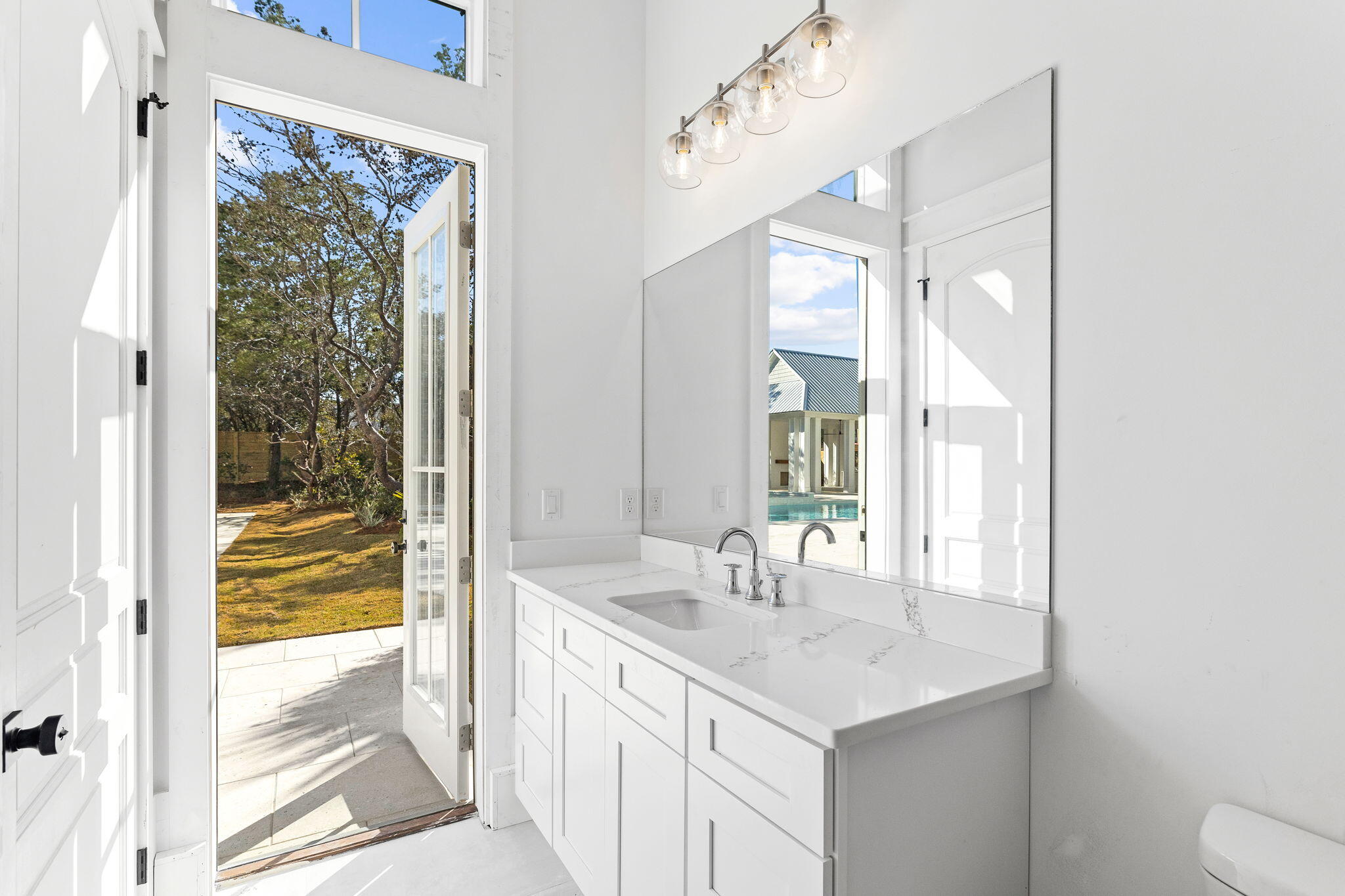 161 Rolling Dunes Drive Santa Rosa Beach, FL 32459 - Photo 58 of 64 a bathroom with a sink and a large mirror