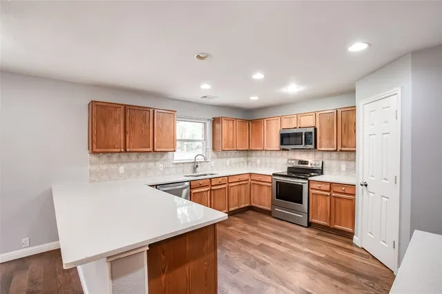 a kitchen with stainless steel appliances granite countertop refrigerator sink and cabinets