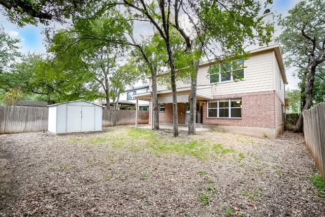 front view of a house with a yard and an trees