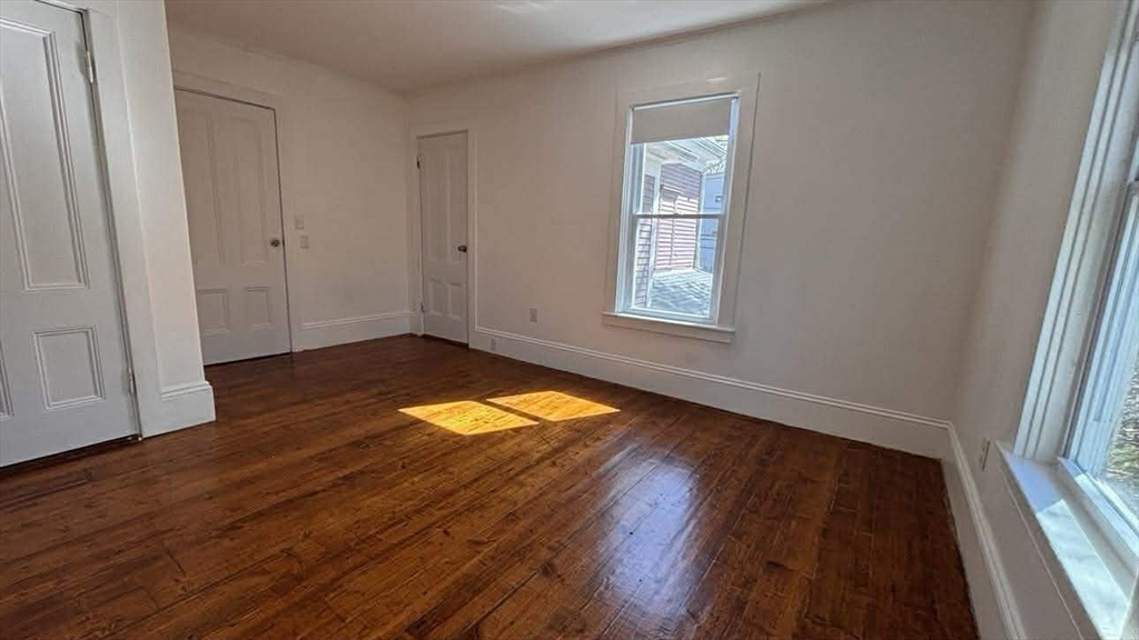 93 Peirce Street, Unit 2 Middleboro, MA 02346 - Photo 11 of 16 an empty room with wooden floor and windows