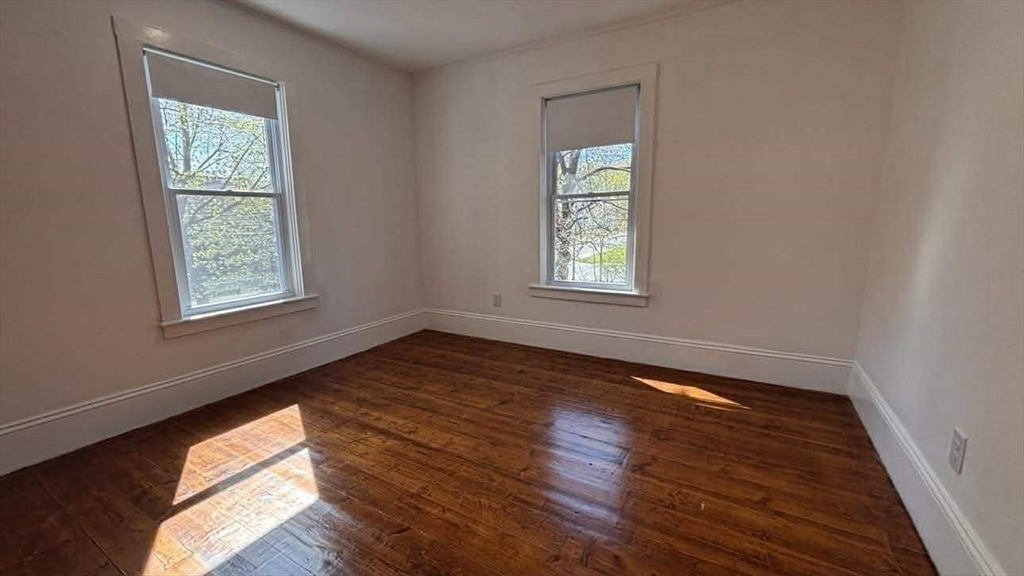 93 Peirce Street, Unit 2 Middleboro, MA 02346 - Photo 13 of 16 a view of an empty room and wooden floor and a window