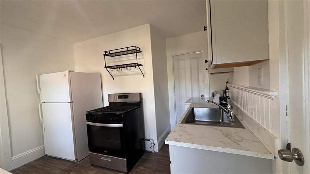 93 Peirce Street, Unit 2 Middleboro, MA 02346 - Photo 2 of 16 a kitchen with a refrigerator and a stove