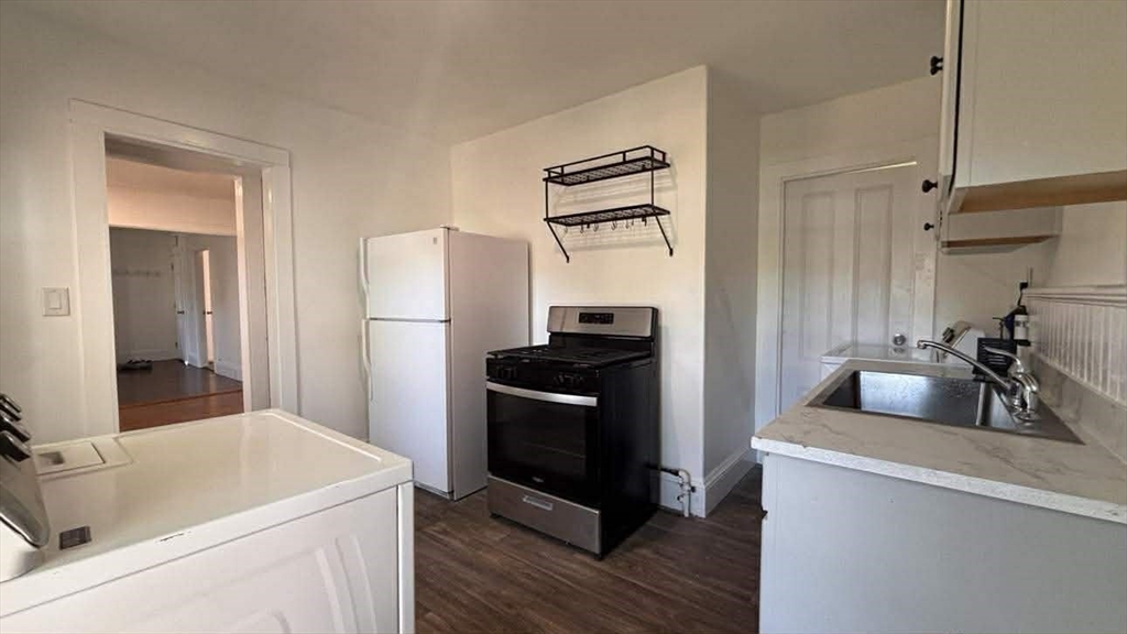 93 Peirce Street, Unit 2 Middleboro, MA 02346 - Photo 3 of 16 a kitchen with a refrigerator sink and wooden floor