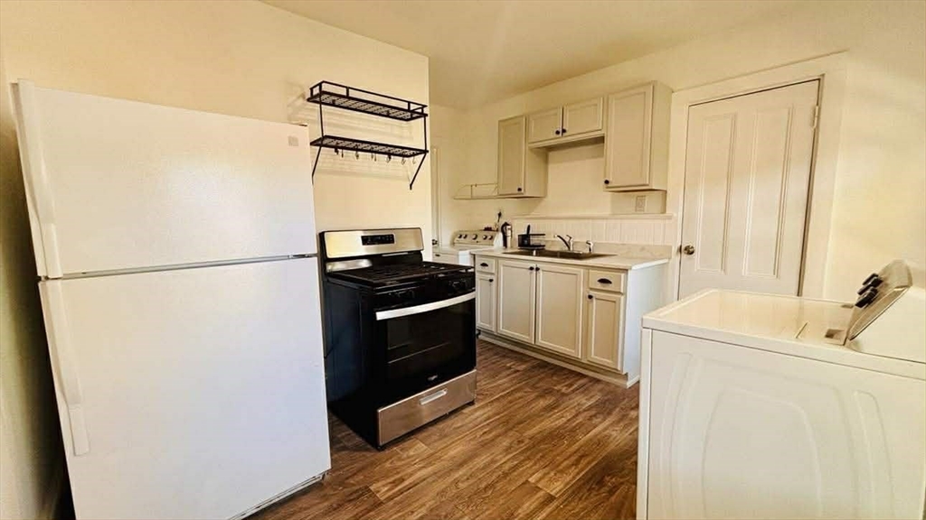 93 Peirce Street, Unit 2 Middleboro, MA 02346 - Photo 5 of 16 a kitchen with stainless steel appliances a refrigerator a stove a sink and white cabinets