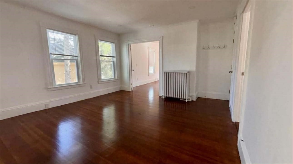 93 Peirce Street, Unit 2 Middleboro, MA 02346 - Photo 7 of 16 an empty room with wooden floor and windows
