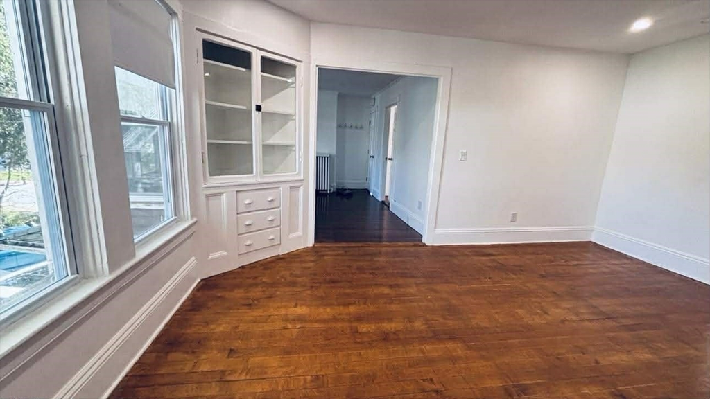 93 Peirce Street, Unit 2 Middleboro, MA 02346 - Photo 10 of 16 a view of an empty room with a window and wooden floor