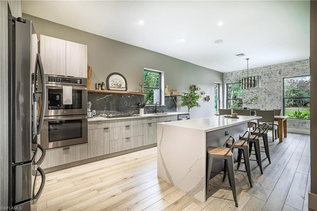 4269 15th Avenue Southwest Naples, FL 34116 - Photo 11 of 30 a kitchen with stainless steel appliances granite countertop a kitchen island hardwood floor and a sink