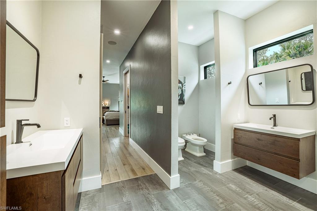 4269 15th Avenue Southwest Naples, FL 34116 - Photo 22 of 30 a bathroom with a sink a toilet and a large mirror