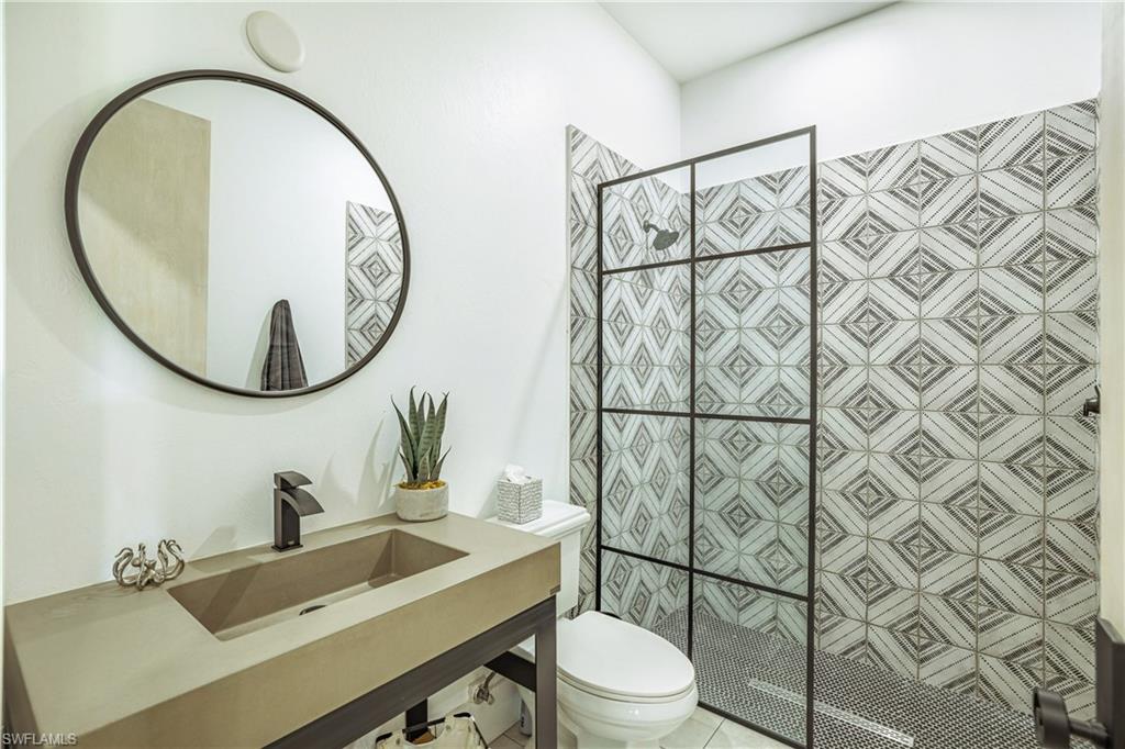 4269 15th Avenue Southwest Naples, FL 34116 - Photo 26 of 30 a bathroom with a sink mirror vanity and toilet