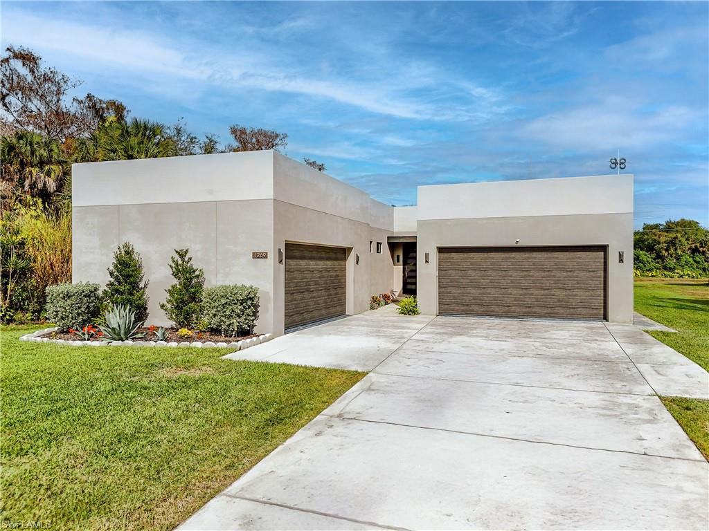 4269 15th Avenue Southwest Naples, FL 34116 - Photo 29 of 30 a front view of a house with a yard and garage