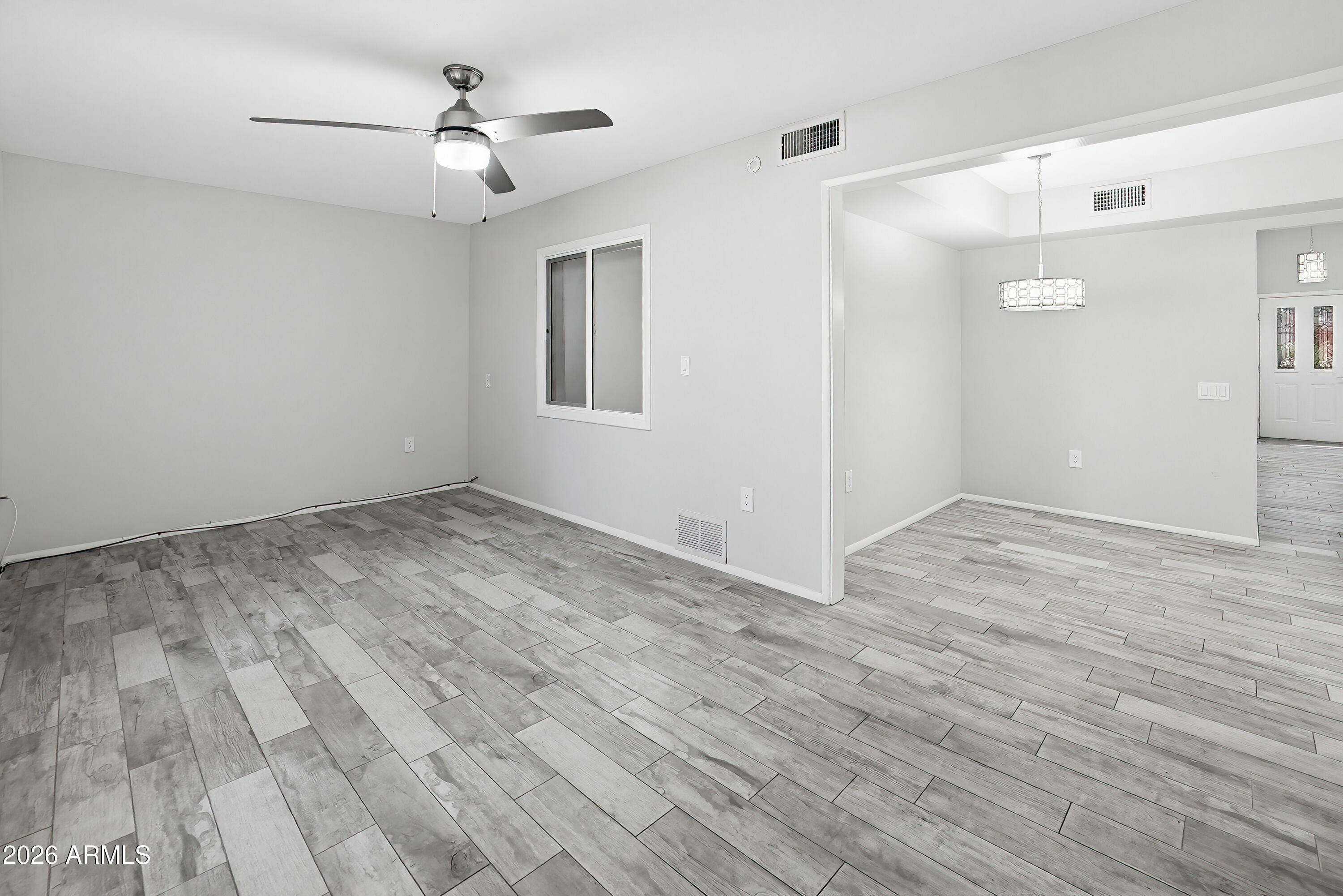 10030 West Royal Oak Road, Unit L Sun City, AZ 85351 - Photo 11 of 30 a view of empty room with wooden floor and fan