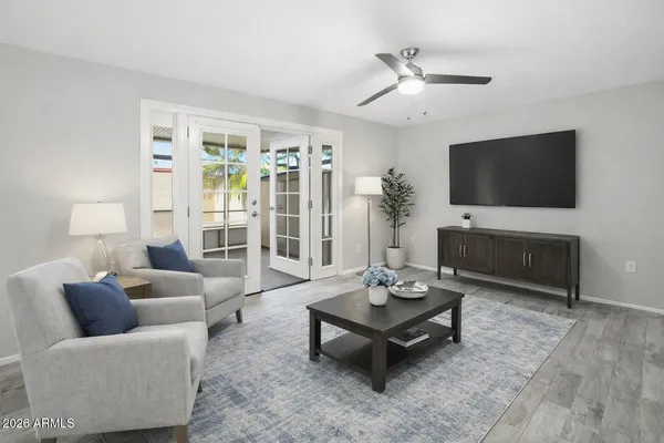 a living room with furniture a flat screen tv and a large window