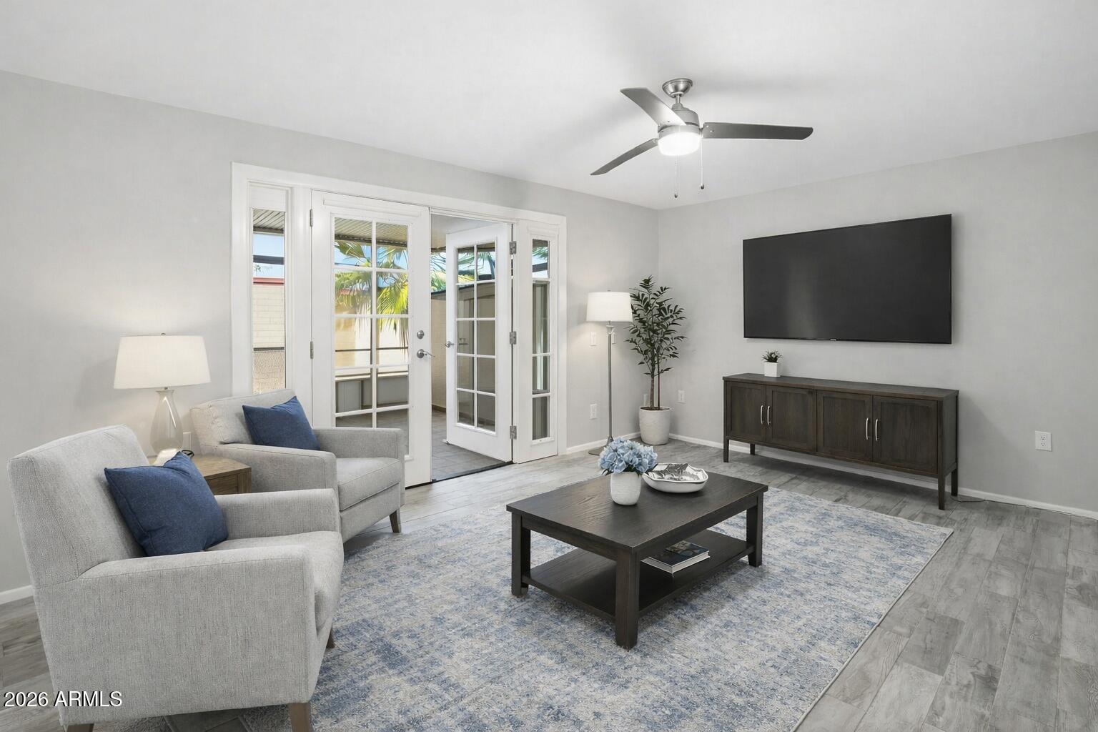 10030 West Royal Oak Road, Unit L Sun City, AZ 85351 - Photo 13 of 30 a living room with furniture a flat screen tv and a large window