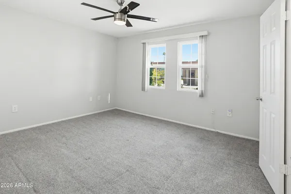 an empty room with a window and a fan