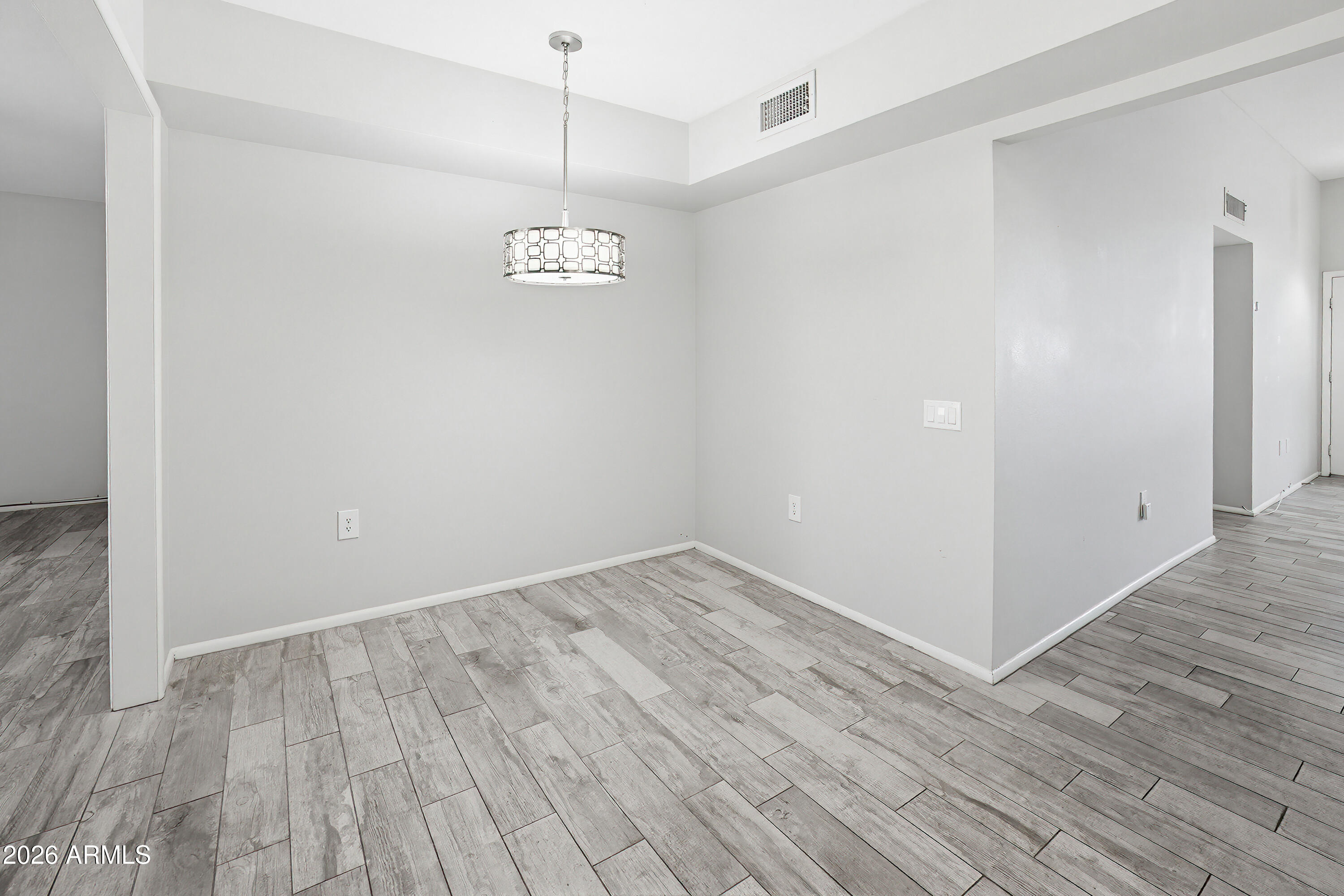 10030 West Royal Oak Road, Unit L Sun City, AZ 85351 - Photo 10 of 30 a view of an empty room with wooden floor