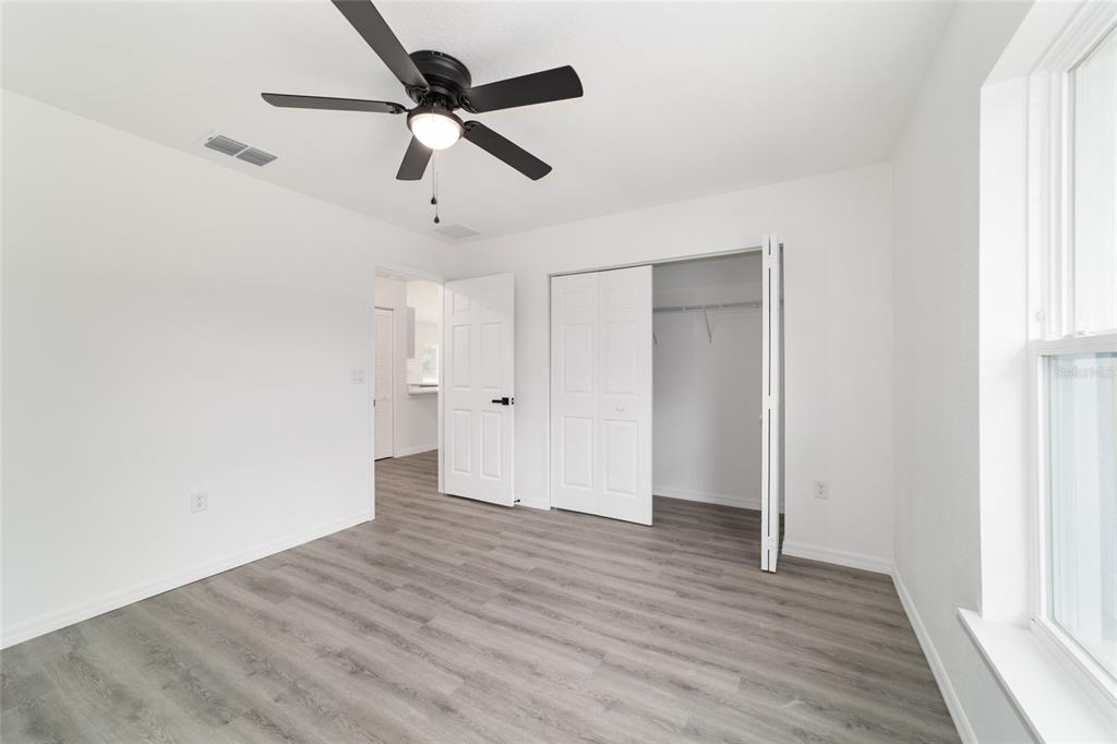 1922 Southwest Little Cliffs Drive Dunnellon, FL 34431 - Photo 24 of 37 an empty room with wooden floor ceiling fan and windows
