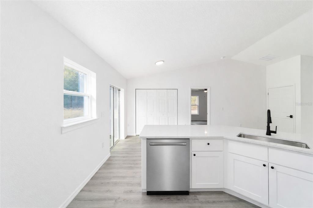 1922 Southwest Little Cliffs Drive Dunnellon, FL 34431 - Photo 5 of 37 a kitchen with a white wooden cabinets and white appliances