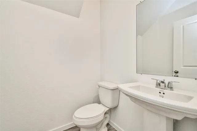 a white toilet sitting next to a bathroom sink