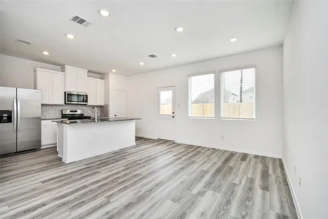a view of kitchen with stainless steel appliances granite countertop a stove a sink and a refrigerator