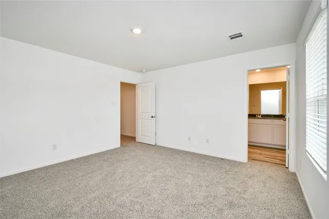 an empty room with closet and windows