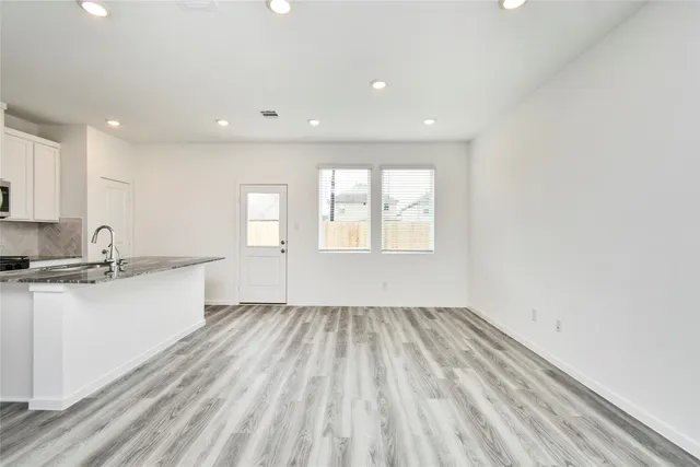 a view of a kitchen with wooden floor and a sink