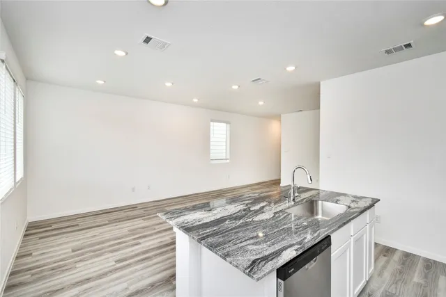 a kitchen with granite countertop sink and stove