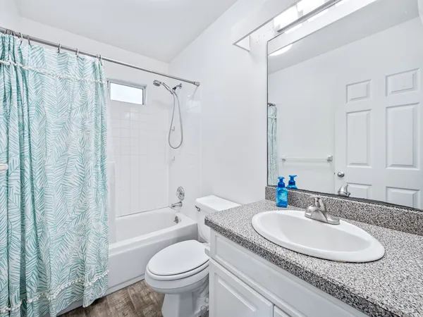 a bathroom with a granite countertop sink toilet and shower