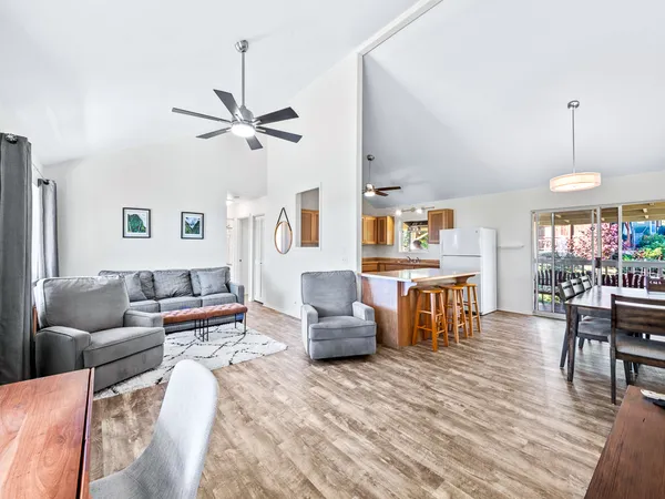 a living room with furniture kitchen view and a chandelier