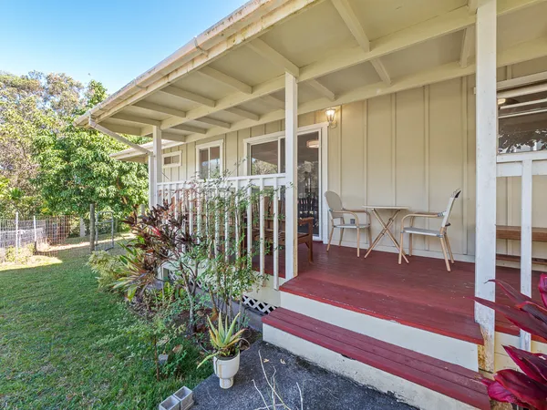 a view of a chair and table in backyard of the house